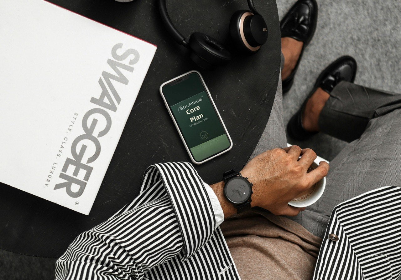 Person using a smartphone with a coffee on a table